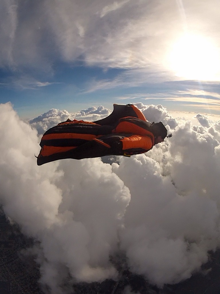 Ariel Legassa in a wingsuit above the clouds
